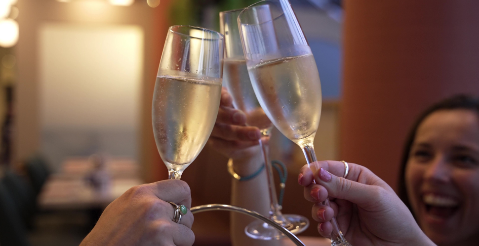 Three champagne glasses being clinked together